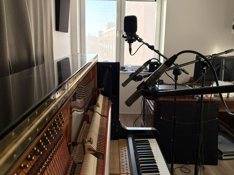 Opnameopstelling met microfoons voor een geopende piano